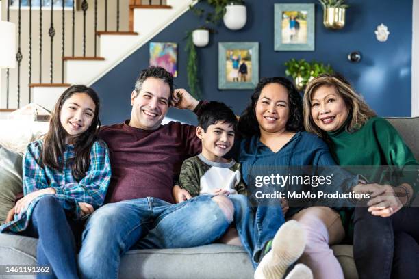 portrait of multi-generational family on couch at home - famiglia con due figli foto e immagini stock