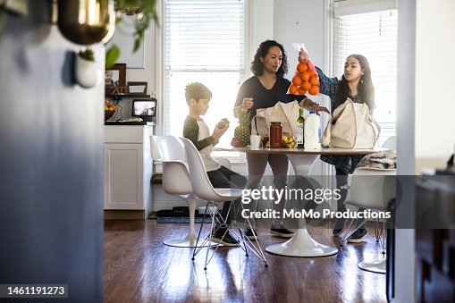 Mother and children unloading groceries