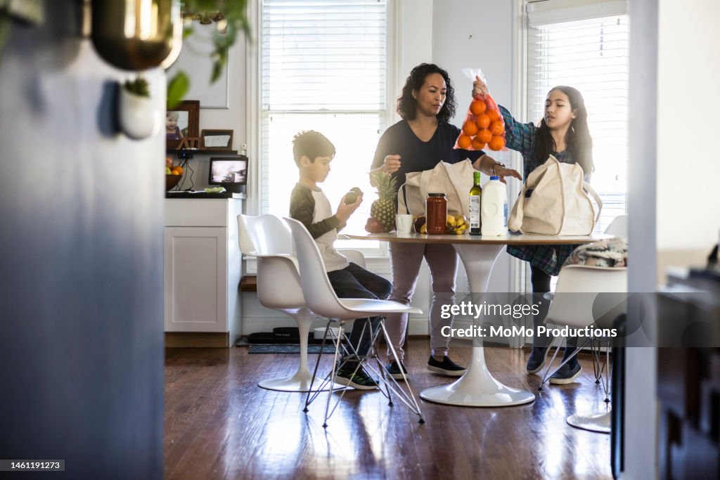 Mother and children unloading groceries