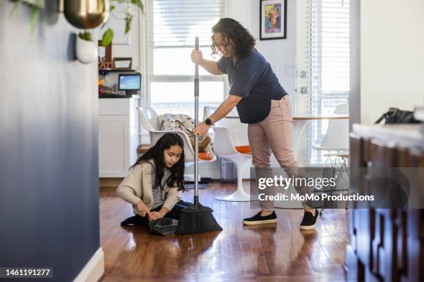 mother and son sweeping the floor in kitchen together - barre class fotografías e imágenes de stock