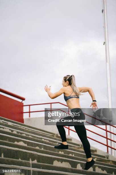 muscular woman running stairs outside in black leggings and spor - saint georges college stock pictures, royalty-free photos & images