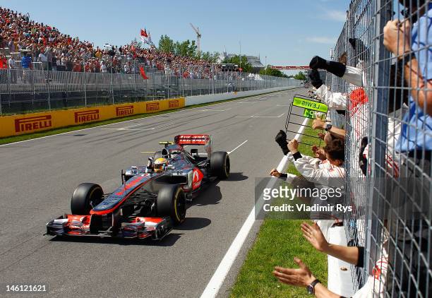 Lewis Hamilton of Great Britain and McLaren celebrates as he crosses the finish line after winning the Canadian Formula One Grand Prix at the Circuit...