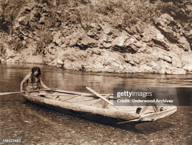 Photogravure of a Yurok in his canoe on the Trinity River, California, 1923.