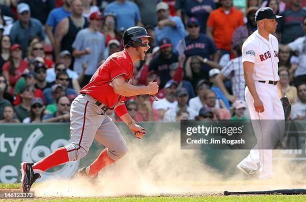 Bryce Harper of the Washington Nationals scores the go-ahead run in the ninth inning as pitcher Alfredo Aceves of the Boston Red Sox looks away...