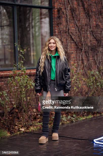 Emili Sindlev wearing a grey mini skirt, green jumper, brown Ugg shoes, red Louis Vuitton bag, and knee-high knitted socking outside Stamm during the...