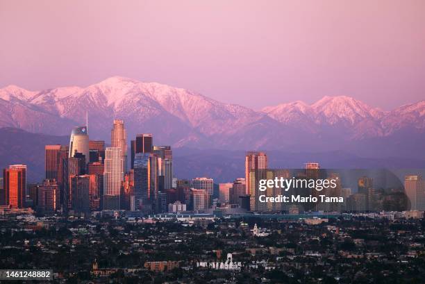 The downtown skyline stands with the snow-capped San Gabriel Mountains visible beyond on January 31, 2023 in Los Angeles, California. California's...