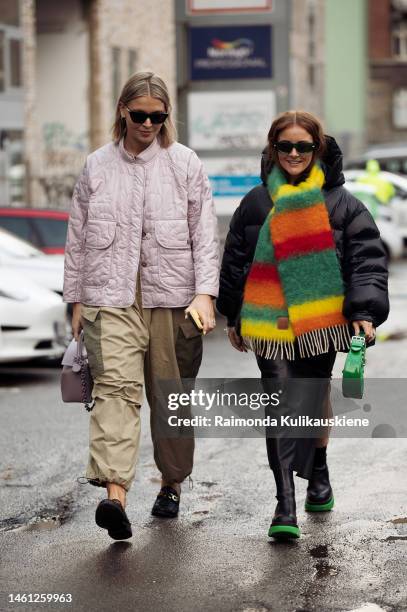 Hollie Mercedes Peters wearing a rose quilted jacket, beige and khaki green cargo pants, loafers, dirty pink bag, and a guest wearing black puffer...