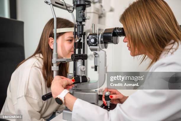 young patient showing tranquility while being assessed by eye test equipment - human eye stock pictures, royalty-free photos & images