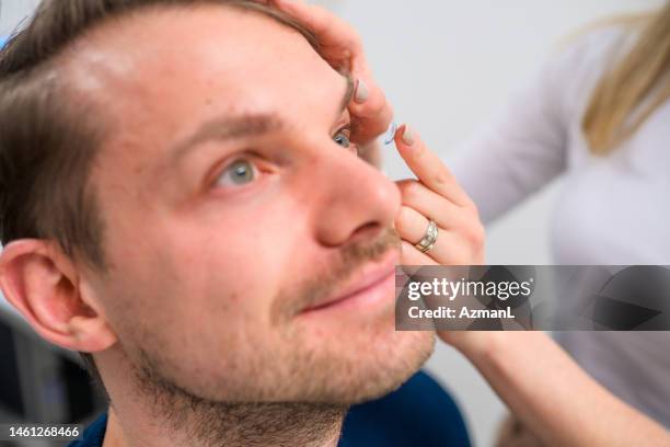 side view close up of caucasian man getting contact lenses on - cornea stock pictures, royalty-free photos & images