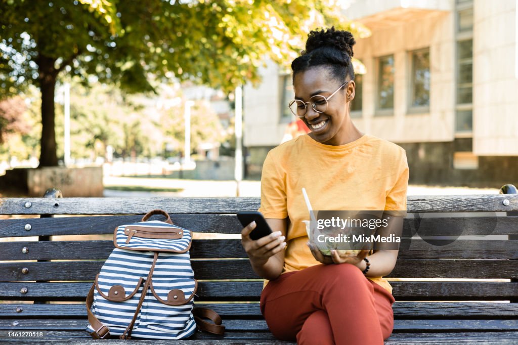 Portrait of a happy Afro young woman ready to eat her salad to go