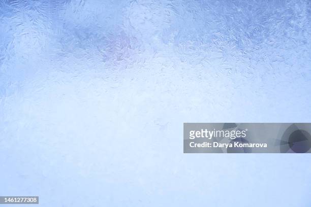 beautiful frosty pattern on the glass in the window. blue background with copy space. - glace texture imagens e fotografias de stock