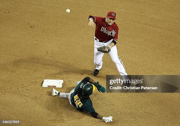 Infielder John McDonald of the Arizona Diamondbacks throws over the sliding Jemile Weeks of the Oakland Athletics as he attempts an unsuccessful...