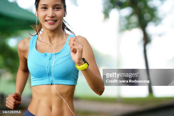 healthy body, motion of young woman outdoors jogging exercise - bauchmuskel stock-fotos und bilder