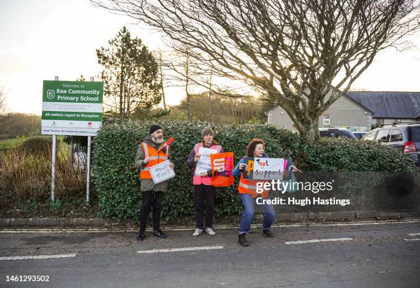 Teachers and supporters wave flags and hold placards as they picket outside Kea Community Primary School during a day of national strikes by many...