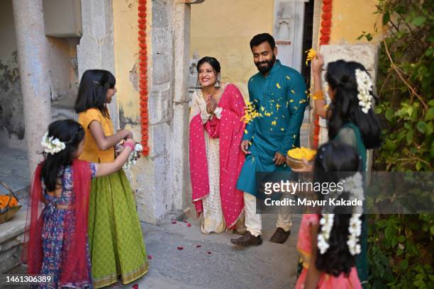 cute girls showering flower petals on guests and welcoming them at the gate - indian arrival stock pictures, royalty-free photos & images