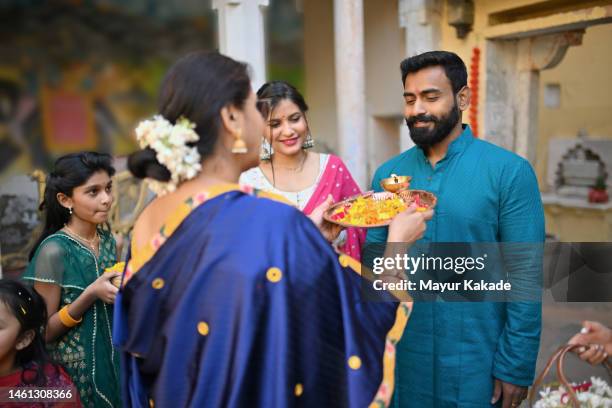 indian mother welcoming son and his family while performing indian rituals - tilaka stock pictures, royalty-free photos & images