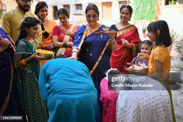 couple takes blessings from their senior mother by touching her feet - indian touching feet stock pictures, royalty-free photos & images