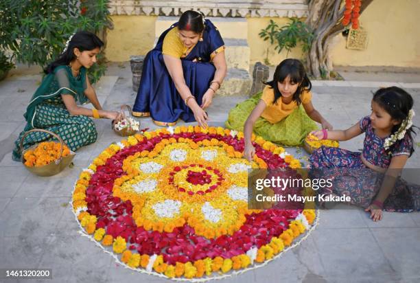 high angle view of grandmother with her grandchildren making flower rangoli - preparation of gudi padwa festival stock pictures, royalty-free photos & images