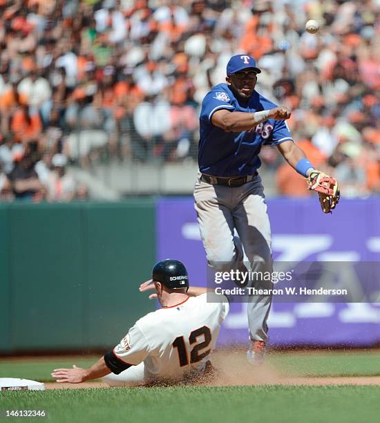 Elvis Andrus of the Texas Ranger gets his throw off to complete the double-play while avoiding the slide of Nate Schierholtz of the San Francisco...