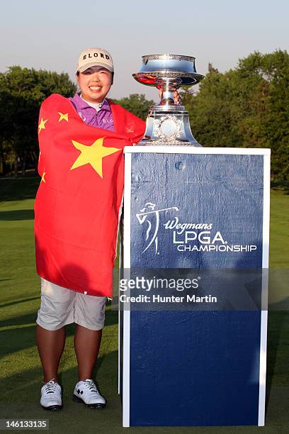 Shanshan Feng of China wraps herself in the flag of China and poses with the championship trophy after winning the Wegmans LPGA Championship at...