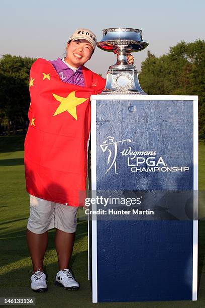 Shanshan Feng of China wraps herself in the flag of China and poses with the championship trophy after winning the Wegmans LPGA Championship at...