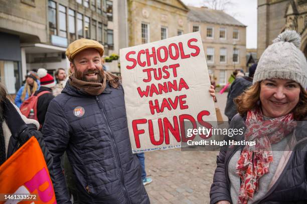 Teachers and supporters wave flags and hold placards as they attend a rally outside Truro Cathedral during a day of national strikes by many unions,...