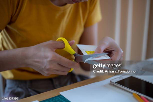 woman's hand cutting paper - scissors stock pictures, royalty-free photos & images