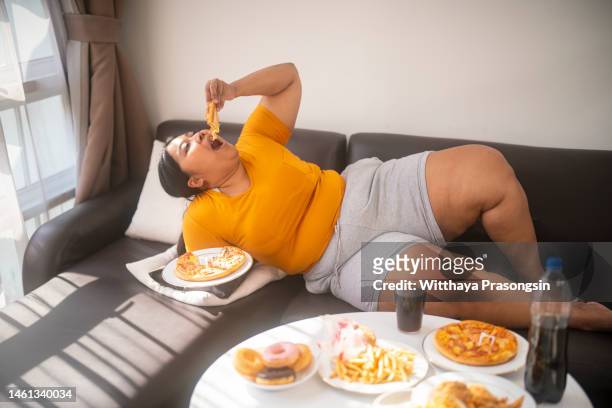 eating sugary food on sofa - excess sugar stock pictures, royalty-free photos & images