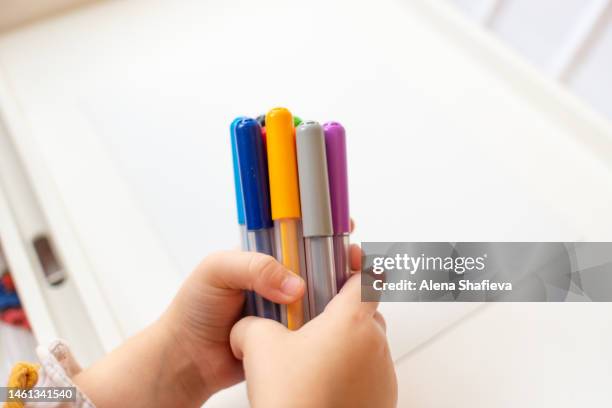 the child holds multi-colored felt-tip pens in his hands - felt tip pen stock-fotos und bilder