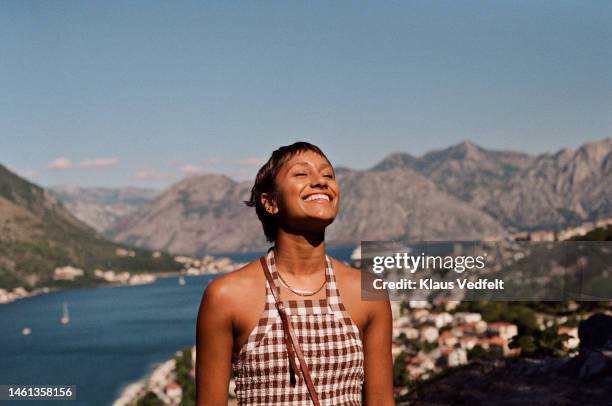 happy woman enjoying sunlight on face during vacation - woman travel stockfoto's en -beelden