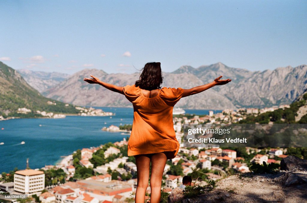 Woman admiring mountains by city on sunny day