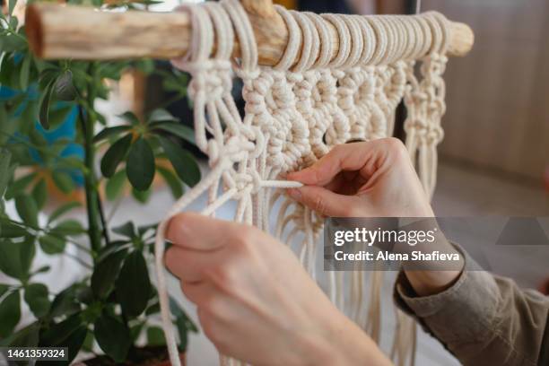 a woman with dreadlocks weaves macrame home decor from cotton threads with a pattern.handmade in macrame technique.creative hobby,eco-friendly boho macrame decor. mental health, home business, home decoration - macrame stock pictures, royalty-free photos & images