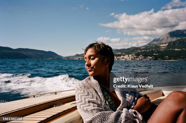 woman with eyes closed sitting in motorboat - speedboat stock pictures, royalty-free photos & images