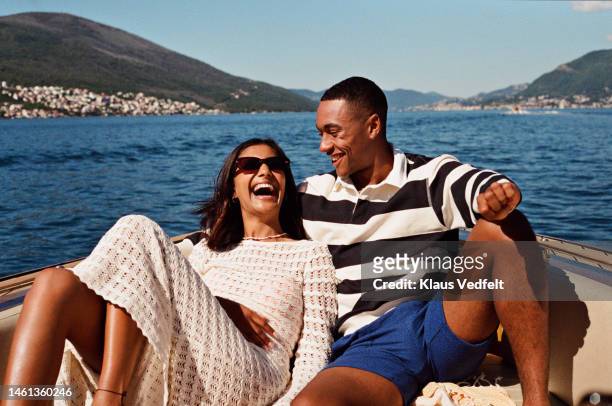 woman laughing with boyfriend in speedboat - striped tshirt stock pictures, royalty-free photos & images