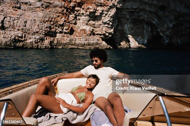 woman resting by boyfriend sitting in motorboat - europe summer stock pictures, royalty-free photos & images