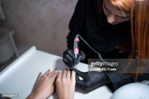 beautician doing manicure for a client at a beauty salon - nail file stock pictures, royalty-free photos & images