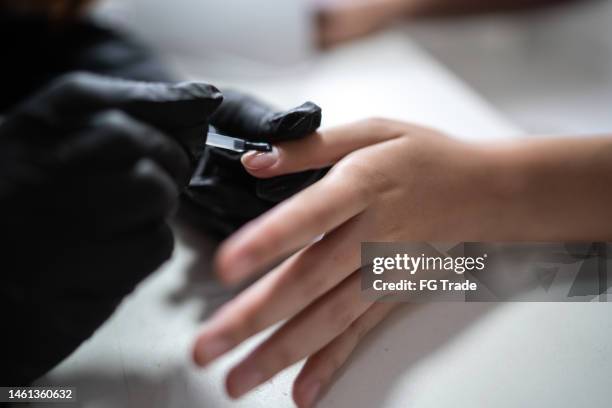 estetista che fa manicure per un cliente in un salone di bellezza - smalto gel foto e immagini stock