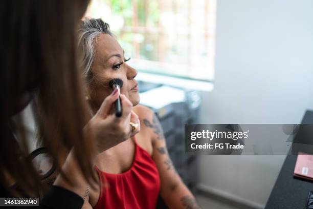 esteticista maquillando a una mujer en un salón de belleza - maquillador fotografías e imágenes de stock