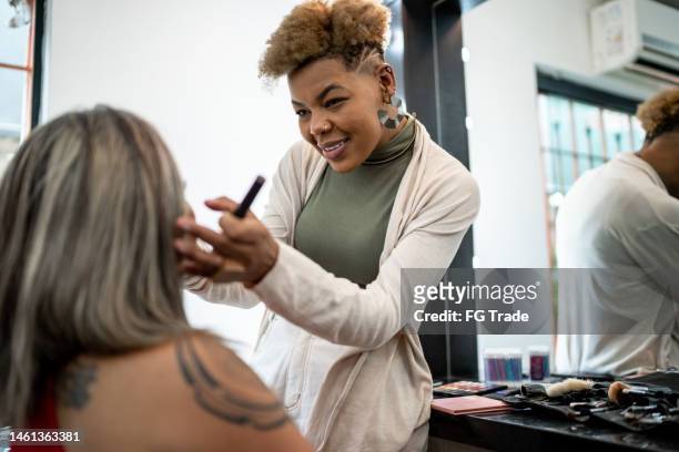 friends doing make-up at a beauty salon - visagist stockfoto's en -beelden