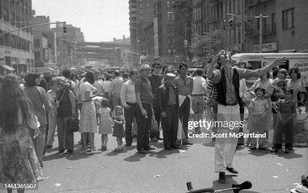 View of a sword swallower performing for onlookers on 9th Avenue in Hell's Kitchen during the International Food Festival, New York, New York, May...