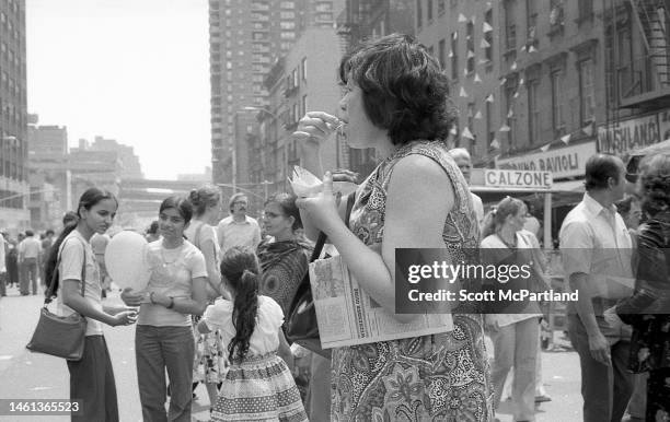 View of an unidentified woman as she eats on 9th Avenue in Hell's Kitchen during the International Food Festival, New York, New York, May 20, 1978.