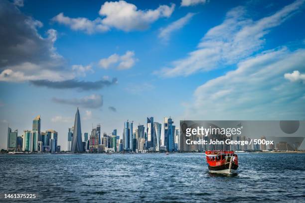 panoramic view of sea and buildings against sky,doha,qatar - qatar port stock-fotos und bilder