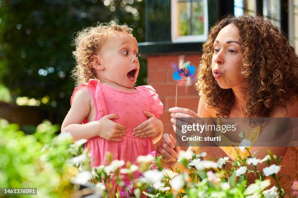 mother and daughter with toy windmill - funny kids stock pictures, royalty-free photos & images