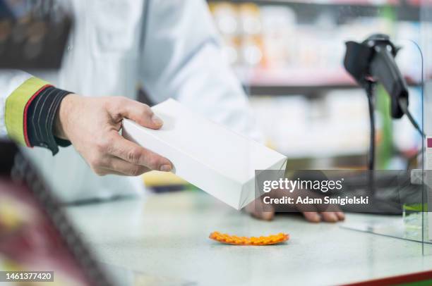 mature pharmacist sells medicines in drugstore - pharmacist and patient stock pictures, royalty-free photos & images