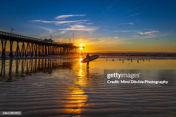 pismo beach surfer at sunset - california photos et images de collection