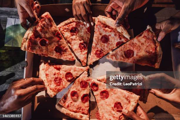 friends eating pepperoni pizza on a party - pepperoni pizza overhead stock pictures, royalty-free photos & images