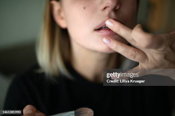 close-up of beautiful woman touching her lips. - glossy lips stock pictures, royalty-free photos & images