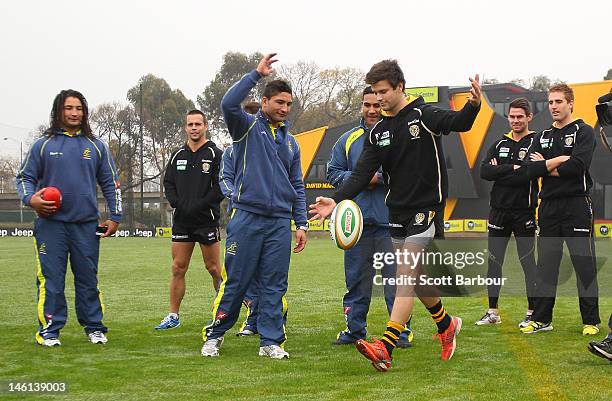 Trent Cotchin of the Richmond Tigers AFL team kicks a rugby ball during an Australian Wallabies fan day at Punt Road Oval on June 11, 2012 in...