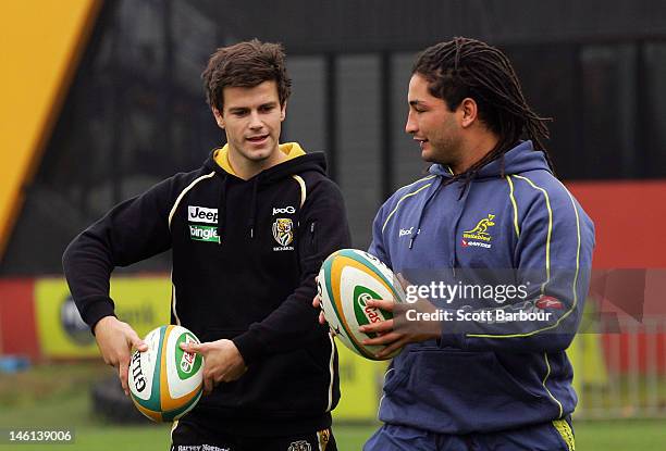 Trent Cotchin of the Richmond Tigers AFL team and Saia Faingaa of the Wallabies pass rugby balls during an Australian Wallabies fan day at Punt Road...