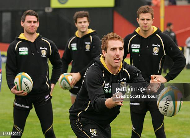 Daniel Jackson of the Richmond Tigers AFL team passes a rugby ball during an Australian Wallabies fan day at Punt Road Oval on June 11, 2012 in...